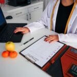 Dietetyczka planuje tygodniowe posiłki przy laptopie z owocami i kalendarzem